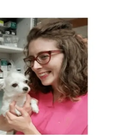 Dr. Georgia Weber's staff photo from Riverside Animal Hospital South where she is smiling and holding a white puppy.